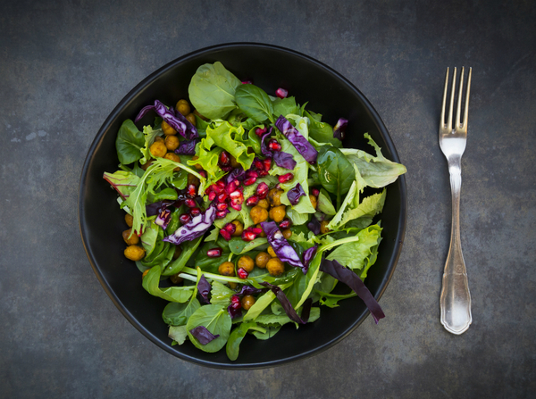 Hands preparing a salad with fresh vegetables